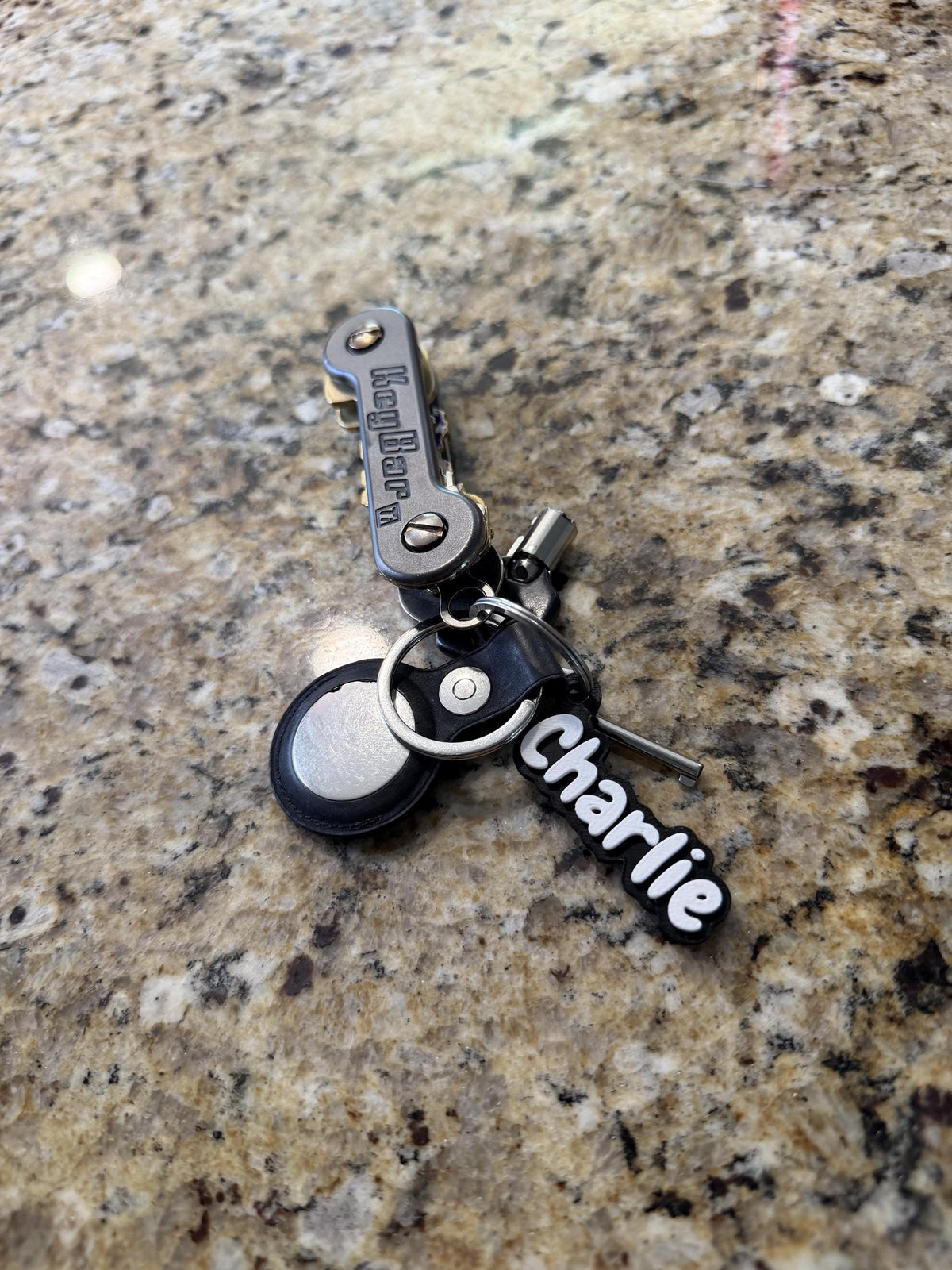 Custom name backpack charm hanging from a zipper