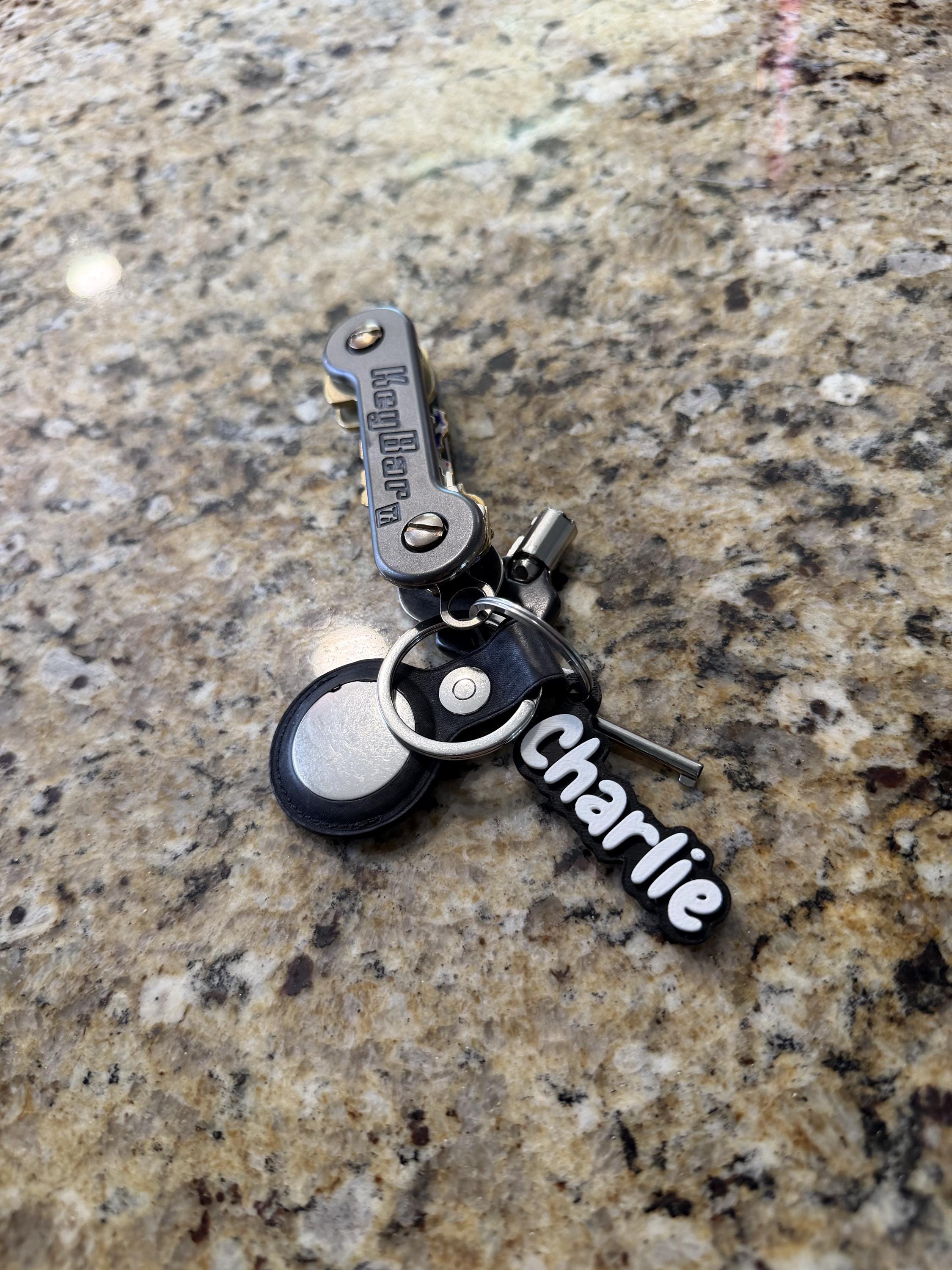 Custom name backpack charm hanging from a zipper